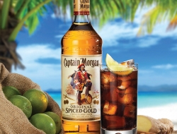 Advertising photograph of a captain Morgan rum bottle and glass served with ice and lemon product photography by Ross Vincent