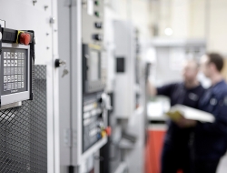 Industrial image of machine and workers checking progress -Industrial photo