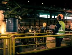 a worker with controls of an overhead crane moving Steel coil