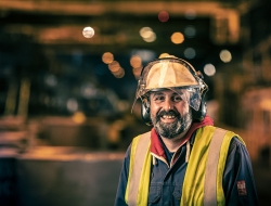 smiling Worker at Liberty Steel Newport with yellow hard hat and bib