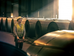 sunlight bursting through on to Steel warehouse and worker