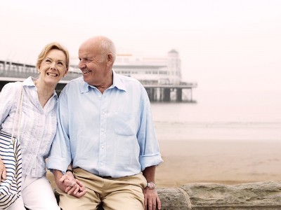 Retired couple sitting by the sea enjoying life