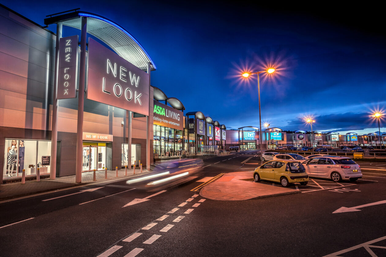 New Look store and row of shops on Team Valley Retail Park Gateshead at night with dark blue sky