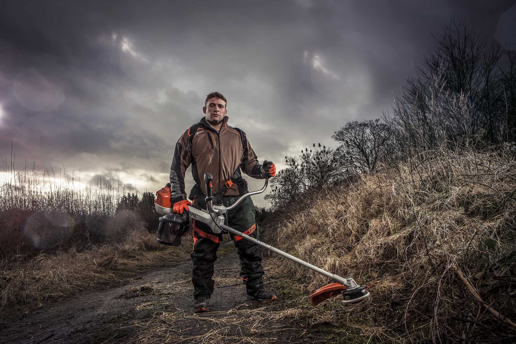 Tom Youngs leicester Rugby Hooker using Stihl Brushcutter tool on location, photography by ross vincent