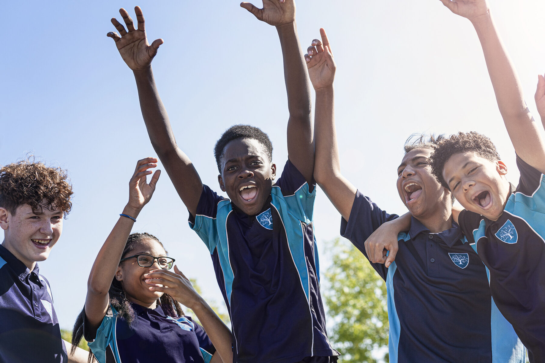 a group of pupil from Balaam school Rubery Birmingham with their arms in the air celebrating joyfully, which is now part of the King Edwards VI schools Foundation Birmingham