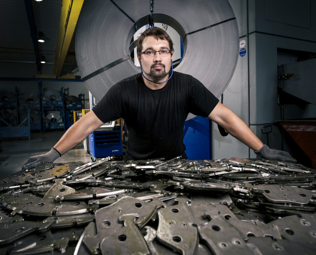 Engineering factory and worker standing before machined parts Industrial photography