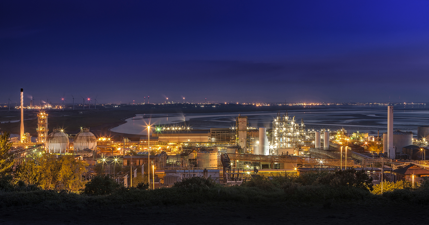view over Stanlow refinery at night with canal and Ellesmere Port in distance