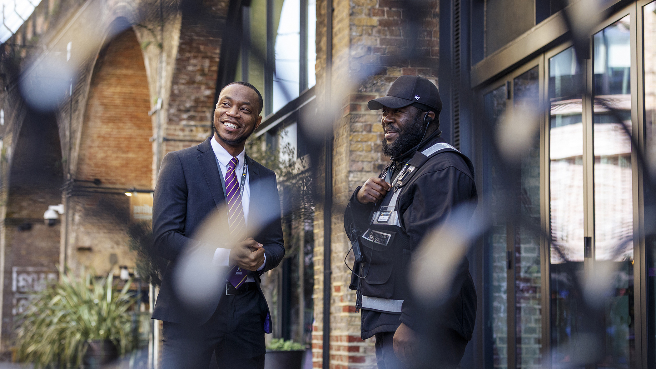 security guard and staff outside at Borough yard London photograph taken through ornate railings